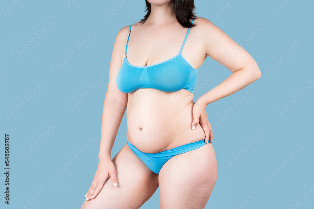 Fototapeta premium Fat woman in underwear on blue background, overweight female body