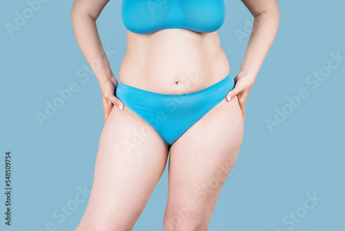 Fat woman in underwear on blue background, overweight female body