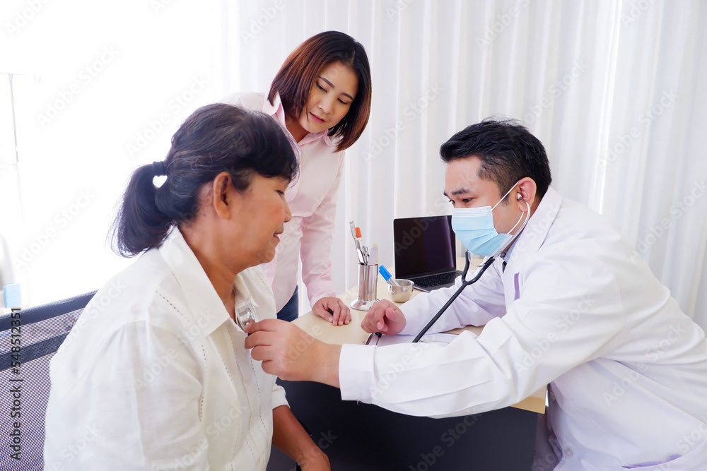Doctor using stethoscope to measure heartbeat of elderly female patient in examination room. Doctor using stethoscope to measure heartbeat of elderly female patient in examination room.