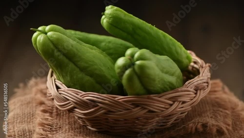 chayote fruit on bamboo basket isolated on white background, It's reduce fatty acid deposits in livers and lower cholesterol levels, slow motion  photo