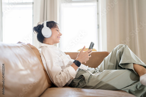 Listening to an audiobook with headphones in the mobile application break for rest. © muse studio