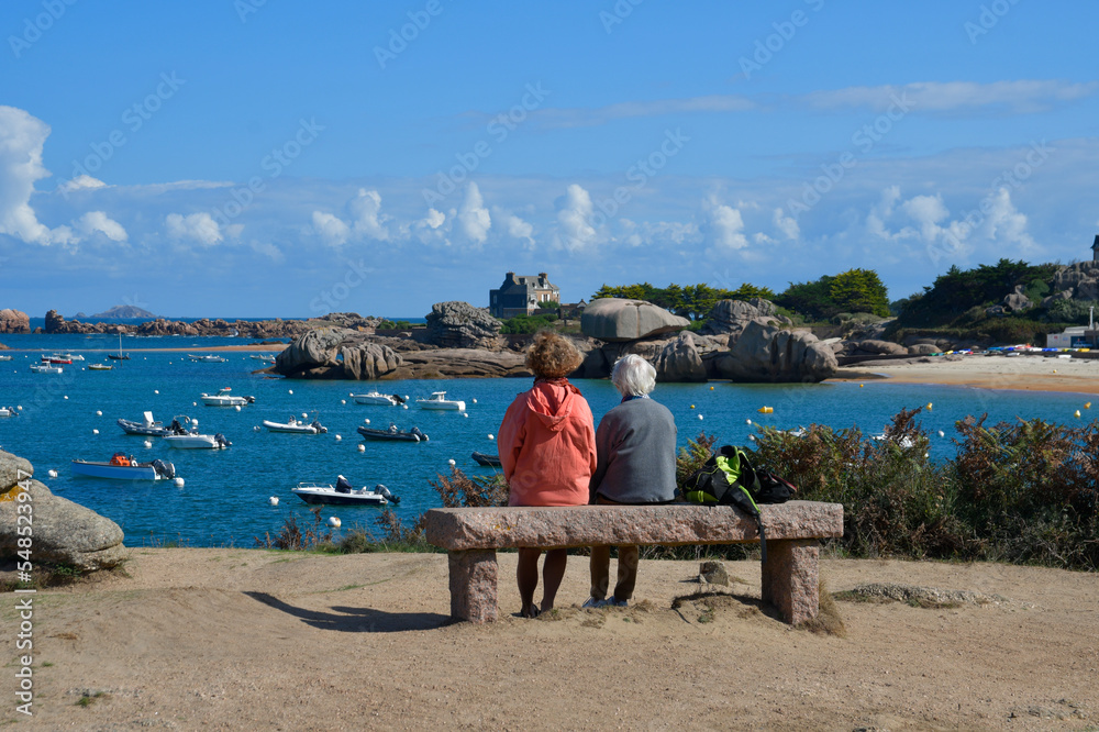 Deux personnes assises sur un banc face  à la mer à Trégastel en Bretagne