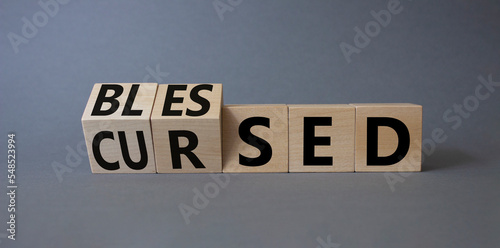 Blessed vs Cursed word symbol. Turned wooden cubes with words Cursed and Blessed. Beautiful grey background. Religious and Blessed vs Cursed concept
