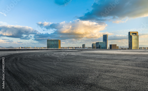 Empty asphalt road and modern city skyline with buildings at sunset in Ningbo, Zhejiang Province, China.