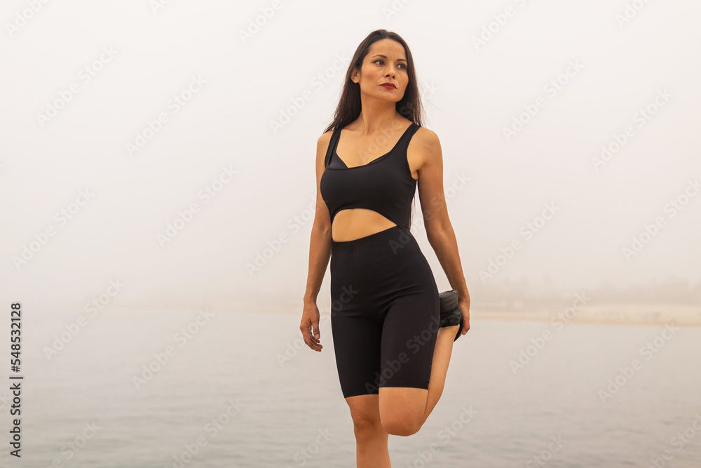 Sportswoman exercising on seashore in foggy weather Sportswoman exercising on seashore in foggy weather
