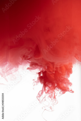 Red color flowing in smoke forms, smooth abstract moving by acrylic paint