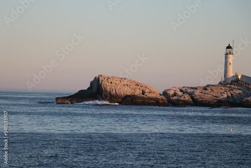Принти на полотні Sunset view of the Isles of Shoals Lighthouse on rocks surrounded by blue sea wa