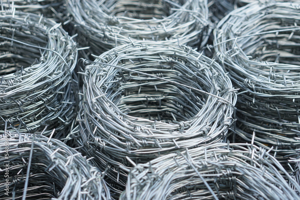 Rolls of barbed wire. Barbed wire is used for make fences , secure property and make border to show the territory of area. Rolls of barbed wire. Barbed wire is used for make fences , secure property and make border to show the territory of area.