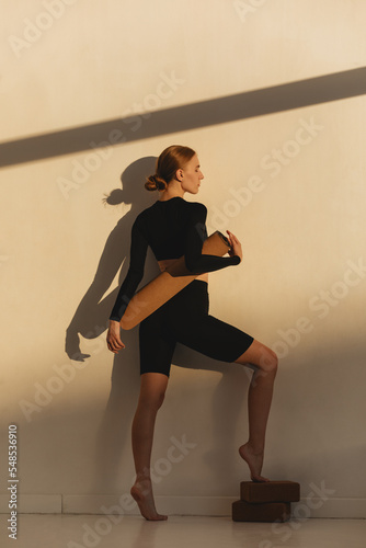 Wellness exercise, woman on floor mat stretching alone, workout day. Fitness training motivation in sunlight, health instructor stretching  and athlete balance lifestyle