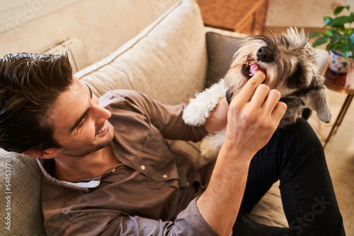 Smiling man sitting on couch with dog