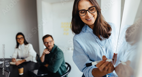 Photos Business woman writing on a board during a presentation
