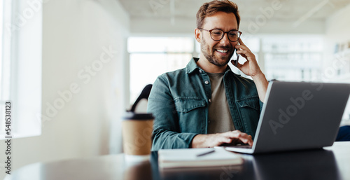 Software designer speaking to his client on the phone in an office