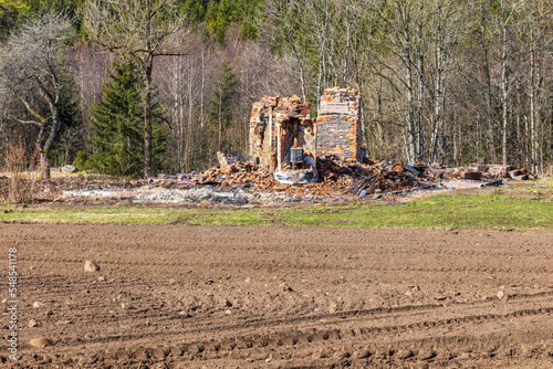 Burned down house in the country by the forest photo