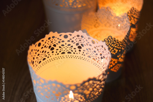 Decorative candle holders on the table, bokeh lights in the background. Selective focus.