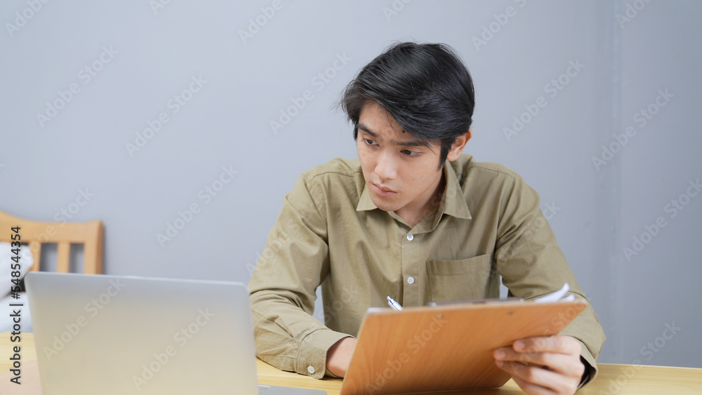 Holiday concept of 4k Resolution. Asian men working at home. computer data entry. students are studying for their own knowledge. Holiday concept of 4k Resolution. Asian men working at home. computer data entry. students are studying for their own knowledge.
