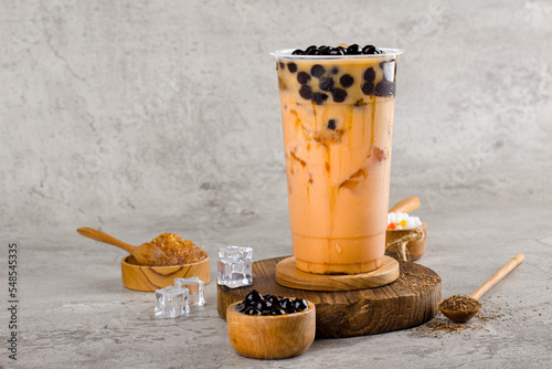 Boba or tapioca pearls is taiwan bubble milk tea in plastic cup with milk tea flavor on texture  background, summers refreshment.