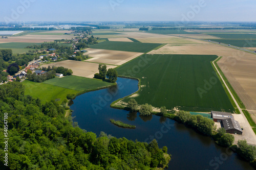 Aerial view of a lake next to a forest and agriculture fields