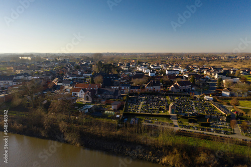 Cemetery and residential area along the Scheldt river, in Wichelen, Belgium photo