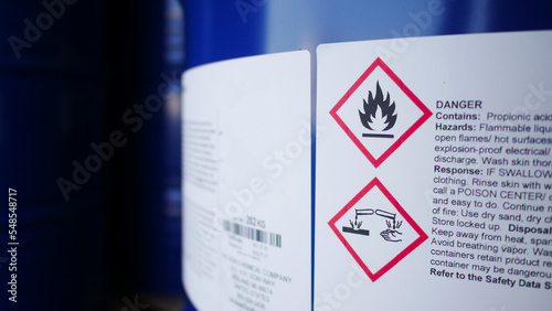 Flammable, acid, volatile, warning labels, mounted on hazardous chemical storage tanks in the warehouse of a chemical industrial factory plant. Waiting for delivery according to the user's order. photo