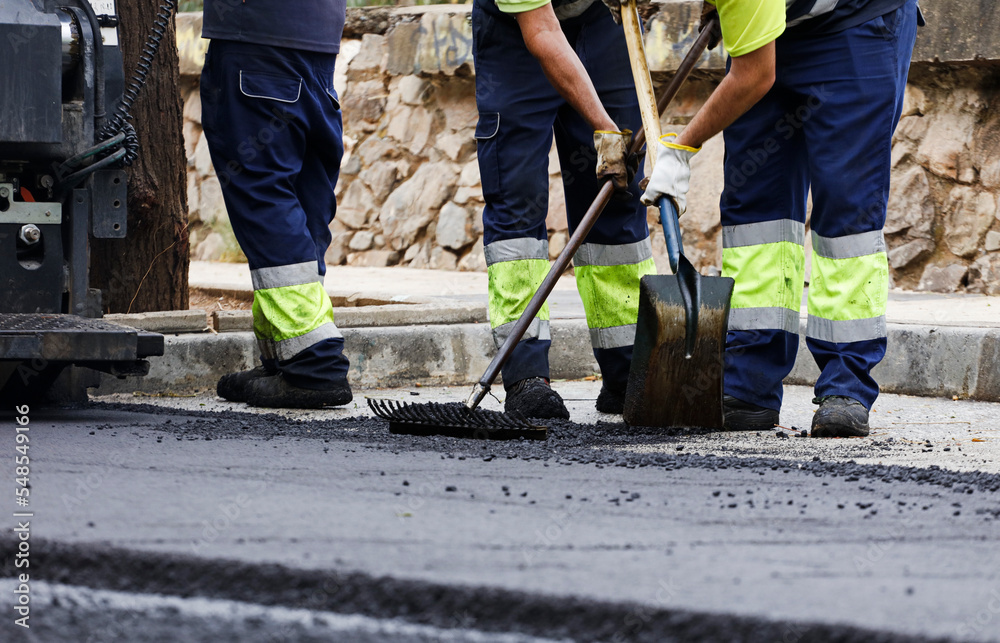 asphalt in the city operators working with tools and uniform asphalt in the city operators working with tools and uniform