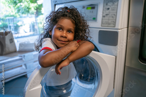 Fotografija Kid whiling away at a communal self-service laundromat