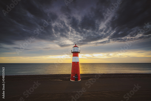 Red & white vintage lighthouse at dutch coast in west kapelle