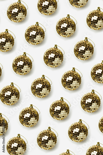 Minimal style Pattern with golden mirror balls on white background, bright glow disco ball as Christmas toy, New Year party concept. Christmas aesthetic vertical holiday background. Trendy top view