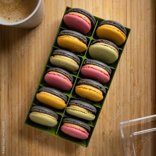 Top view of colorful French macarons in a box over the wooden surface