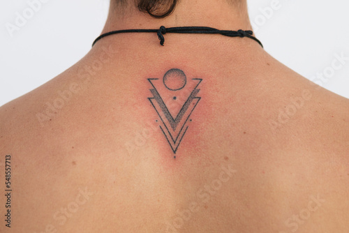 Recent Finished tattoo on back of alternative young man
Detail of recent tattoo finished with the red skin irritation, minimalist design with dots triangles and circles photo