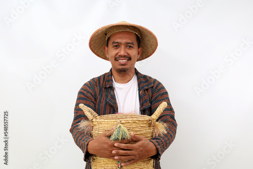 Happy asian farmer standing while holding an empty basket. Isolated on white background