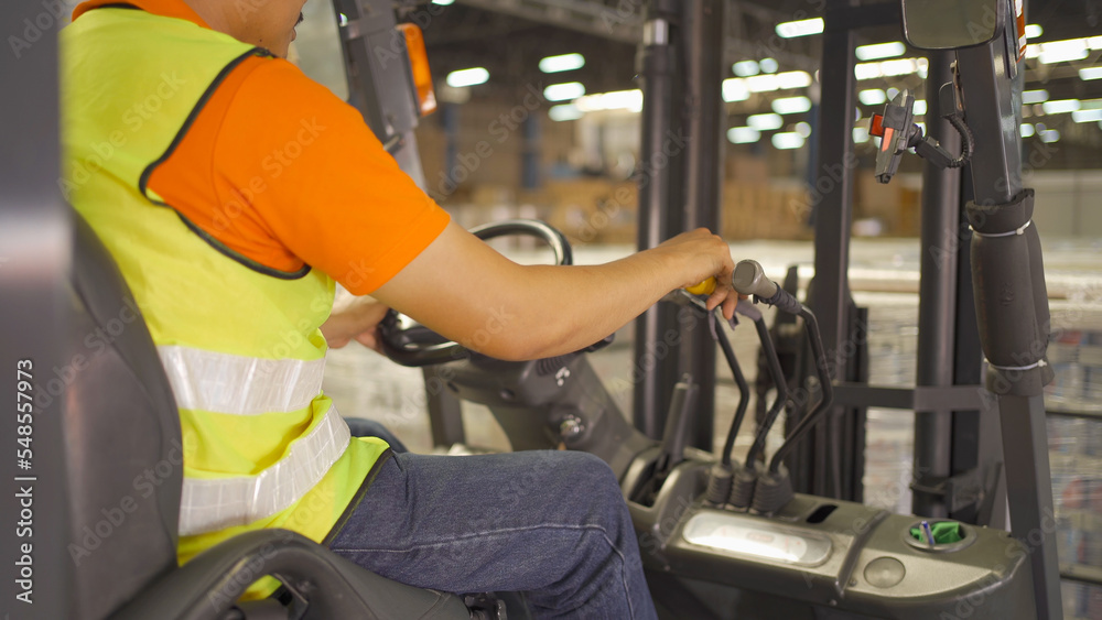Asian worker driving Fork lift truck with pallet car vehicle in warehouse retail store industry. Rack of stock storage. Cargo in ecommerce and logistic. Depot. People lifestyle. Shipment service Asian worker driving Fork lift truck with pallet car vehicle in warehouse retail store industry. Rack of stock storage. Cargo in ecommerce and logistic. Depot. People lifestyle. Shipment service