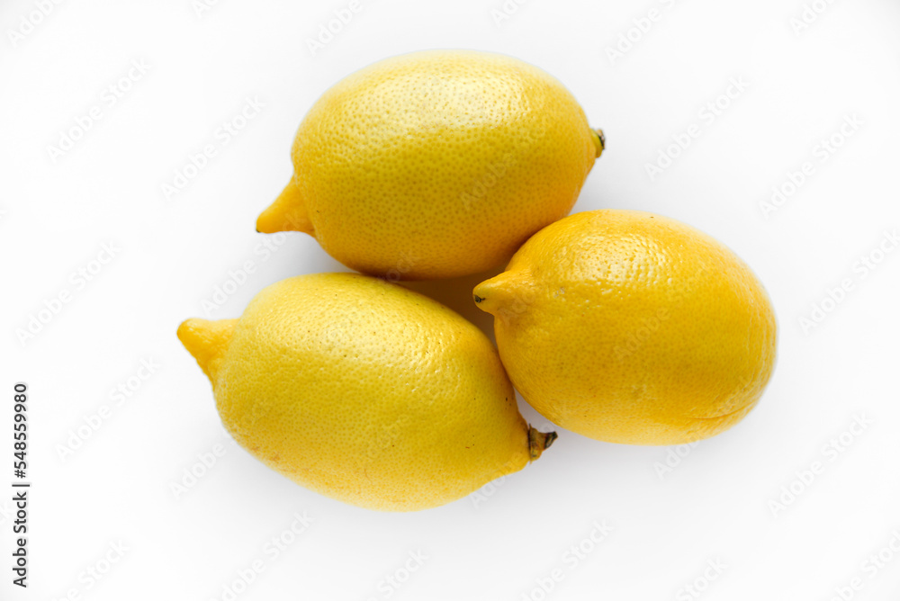 Yellow ripe lemon on a white background. Juicy lemons close-up. Isolate of the fruit of a yellow lemon. Yellow ripe lemon on a white background. Juicy lemons close-up. Isolate of the fruit of a yellow lemon.
