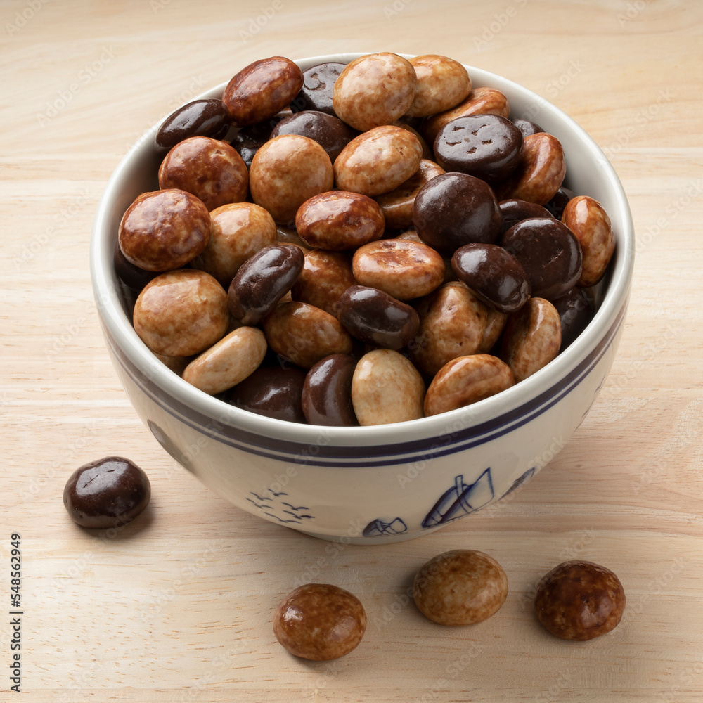 Chocolate and coffee tasting sugar covered on traditional Dutch kruidnoten, cookies, in a bowl close up Chocolate and coffee tasting sugar covered on traditional Dutch kruidnoten, cookies, in a bowl close up
