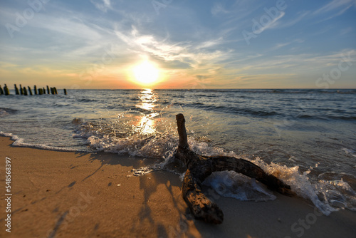 Konar na plaży morza Bałtyckiego przy zachodzie słońca 
