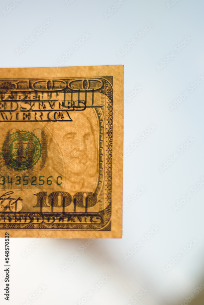 Hundred dollar bill in bright sunlight. Close-up with a blurred background. Hundred dollar bill in bright sunlight. Close-up with a blurred background.