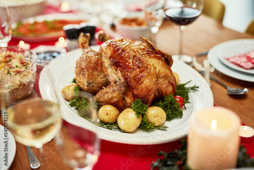 Thanksgiving, turkey and food with a meal on a dining room table for tradition in an empty room. Christmas, chicken and dinner of a place setting for a celebration even in a home or house closeup