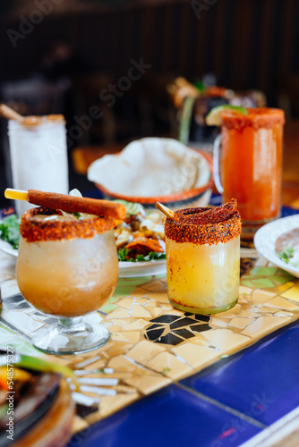 Drink and food sit on a table at a Mexican restaurant. 