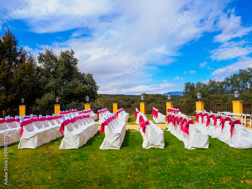decorated chairs on a sunny day for an outdoor bridal ceremony in the sunny day