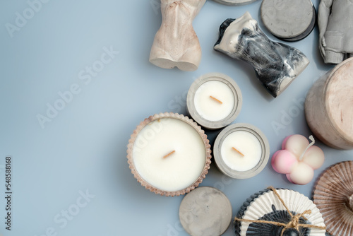 candles and handmade decor on a blue background, space for text, top view