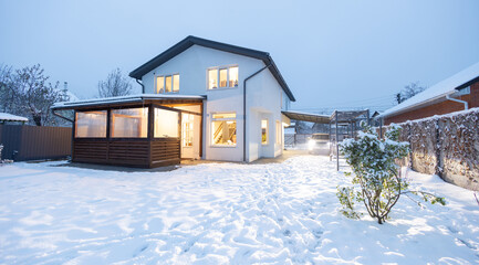 Private white house in winter at sunset