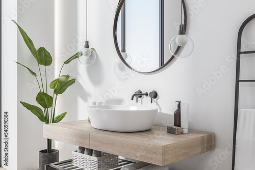 Fotomurale Perspective view on stylish sunlit minimalistic wooden sink cabinet with round mirror above and white wall on background