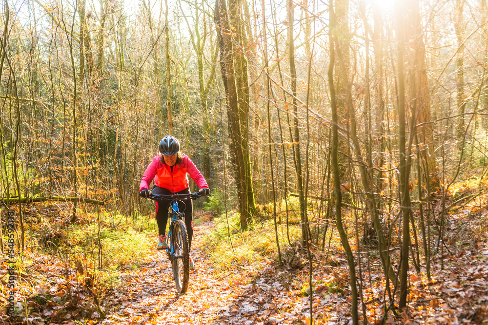 Woman riding a bike in the woods Woman riding a bike in the woods