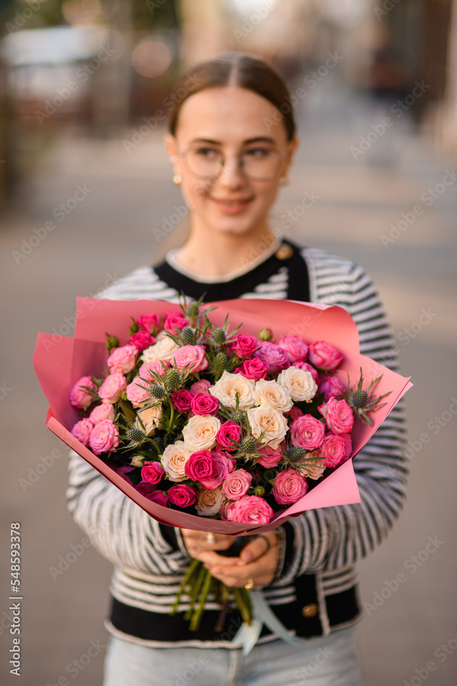 Fototapeta premium selective focus on bouquet with roses and thistles in hands of woman