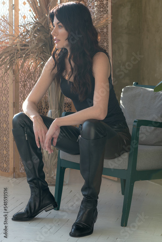 Fashionable woman in black clothes sitting 