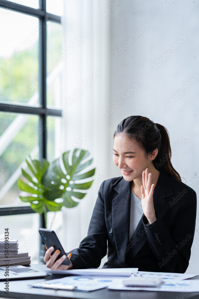 Portrait of an Asian businesswoman using a telephone to contact customers. online products to sell products and take orders for delivery of packages. Portrait of an Asian businesswoman using a telephone to contact customers. online products to sell products and take orders for delivery of packages.