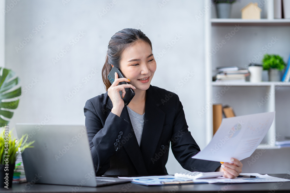 Portrait of an Asian businesswoman using a telephone to contact customers. online products to sell products and take orders for delivery of packages. Portrait of an Asian businesswoman using a telephone to contact customers. online products to sell products and take orders for delivery of packages.