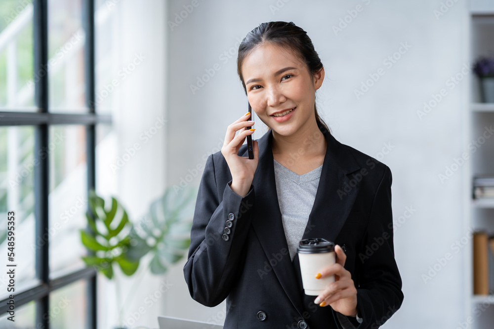 Portrait of an Asian businesswoman using a telephone to contact customers. online products to sell products and take orders for delivery of packages. Portrait of an Asian businesswoman using a telephone to contact customers. online products to sell products and take orders for delivery of packages.