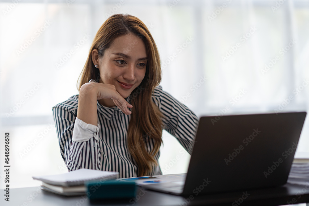 Asian businesswoman thinking Analyze the expected and proud performance of the business in her office.
