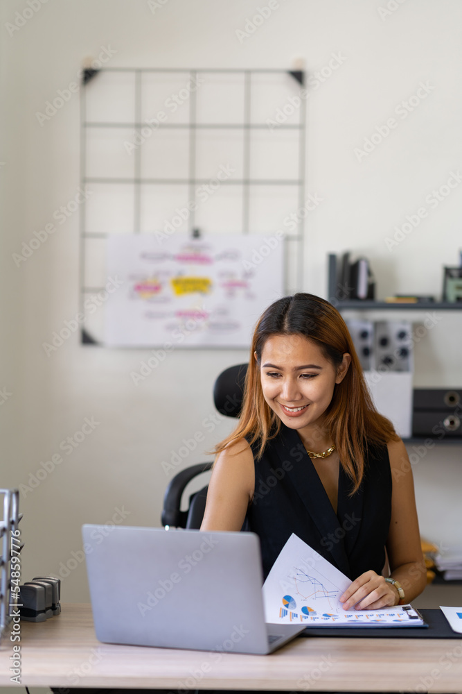 Portrait of an Asian businesswoman thinking View financial statements and make marketing plans, review documents, calculate numbers and record information in a notebook. Portrait of an Asian businesswoman thinking View financial statements and make marketing plans, review documents, calculate numbers and record information in a notebook.