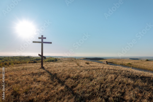 One Christian cross on hill. Early morning at dawn in summer. Sunrise with blue heaven. High quality photo